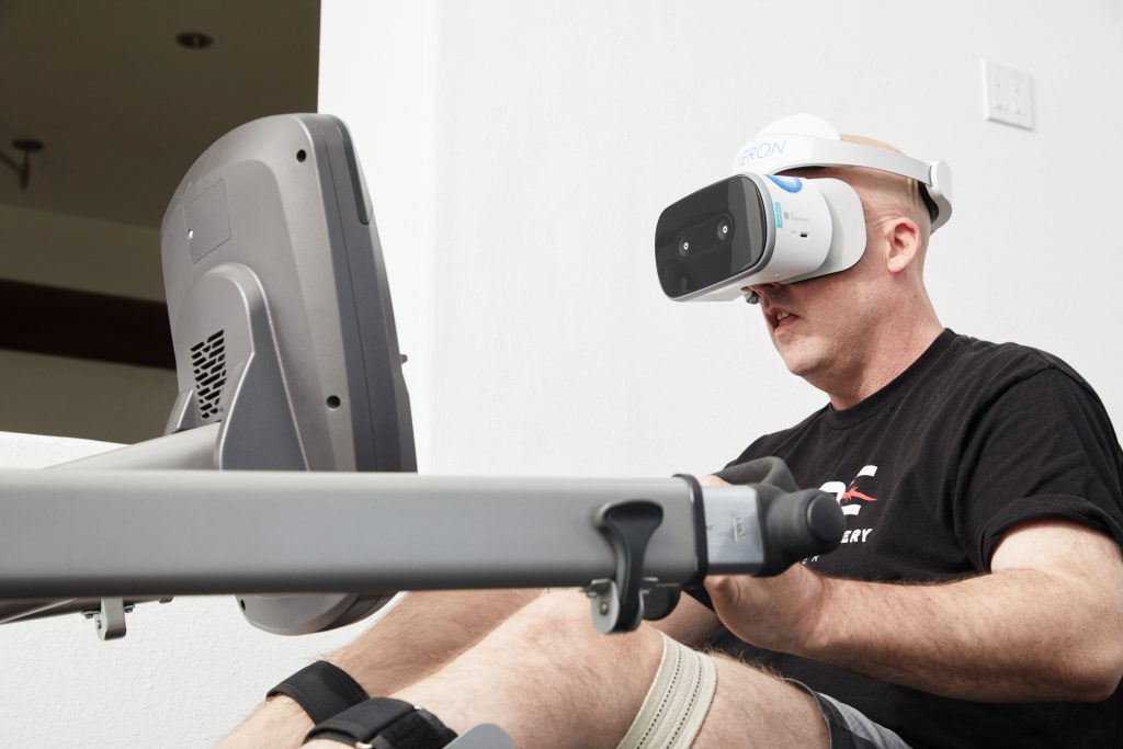 A MIERON user rowing while wearing the VR neurotherapy headset
