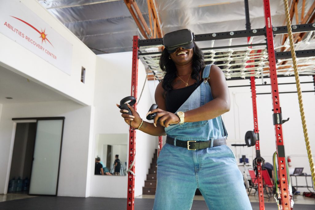 A MIERON user smiling during a VR neurotherapy session with hand controllers